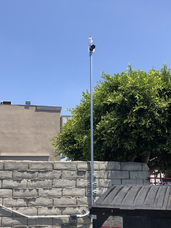 The final setup involves mounting a high-performance video security camera on an EMT conduit pipe for optimal positioning and stability. This camera delivers superior 4K resolution, ensuring crystal-clear imagery for effective surveillance. It employs a reliable wireless bridge technology to transmit the video feed securely over distances. The system routes the live stream directly back to the central building, where it integrates seamlessly with the Network Video Recorder (NVR). This configuration enhances monitoring capabilities, allowing real-time recording and remote access while minimizing wiring needs. Overall, the installation provides robust security without compromising on video quality or operational efficiency.